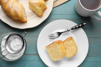 Photo of Delicious sponge cake served on light blue wooden table, flat lay