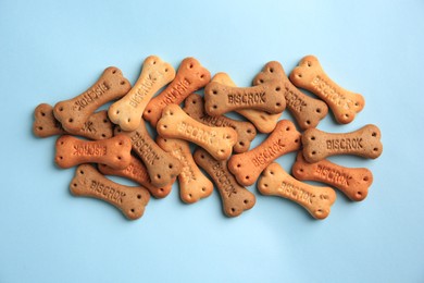 Bone shaped dog cookies on light blue background, flat lay
