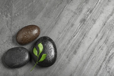 Photo of Spa stones with leaves and space for text on grey background, flat lay