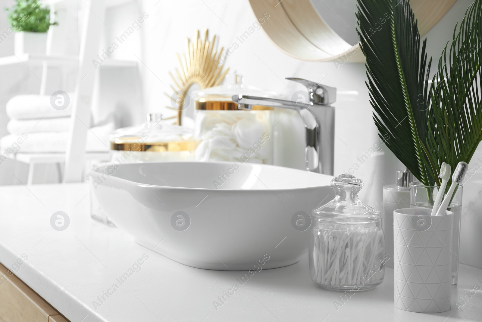 Photo of Cotton swabs near sink on white countertop in bathroom