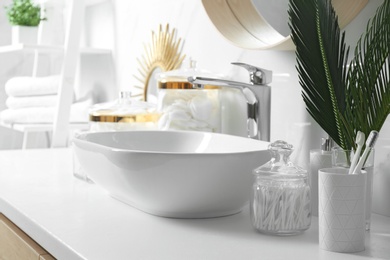 Photo of Cotton swabs near sink on white countertop in bathroom