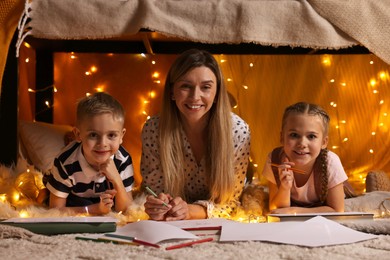 Photo of Mother and her children drawing in play tent at home