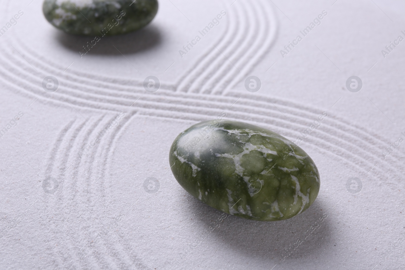 Photo of Stones on sand with pattern. Zen concept