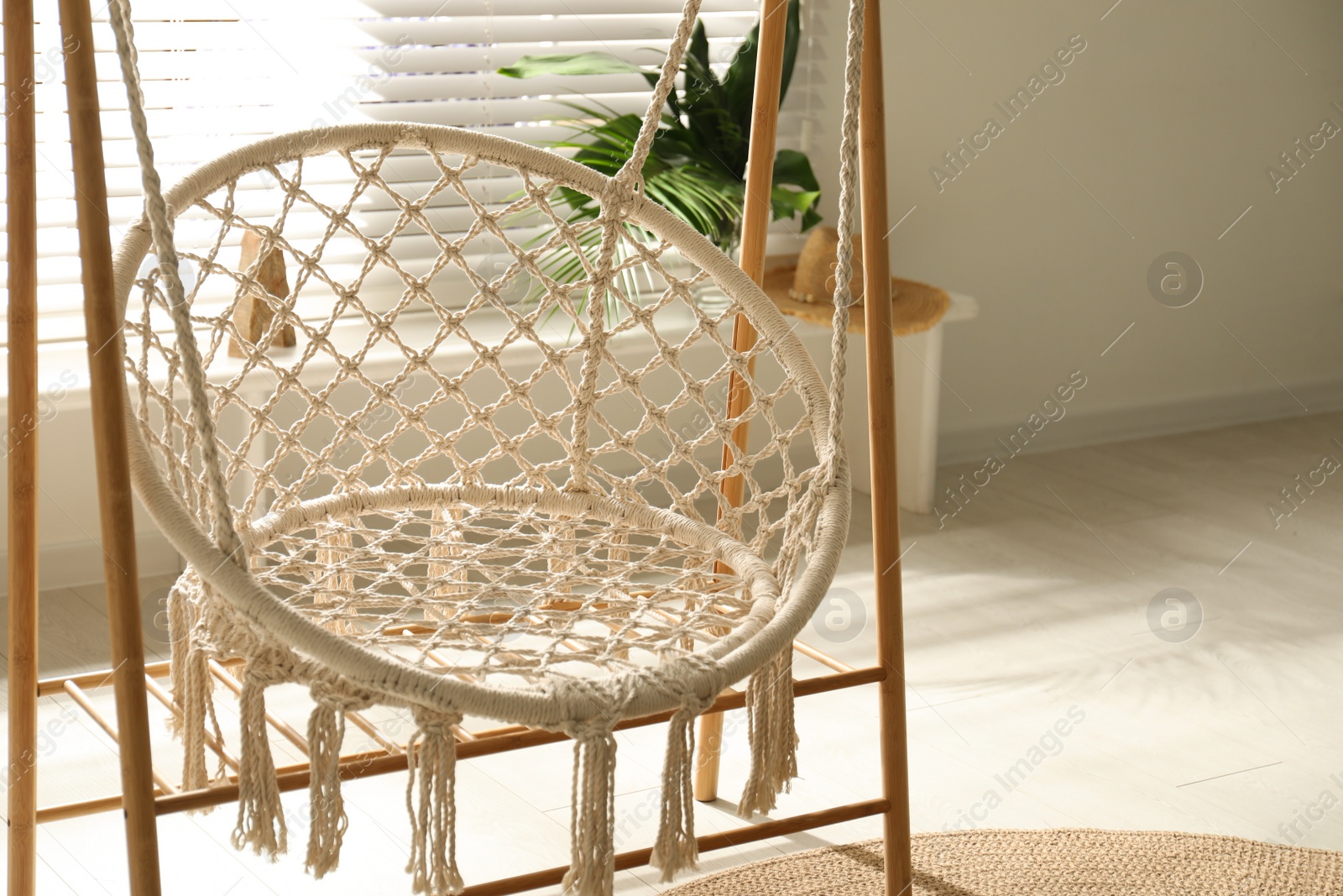 Photo of Comfortable hammock chair in stylish room. Interior design