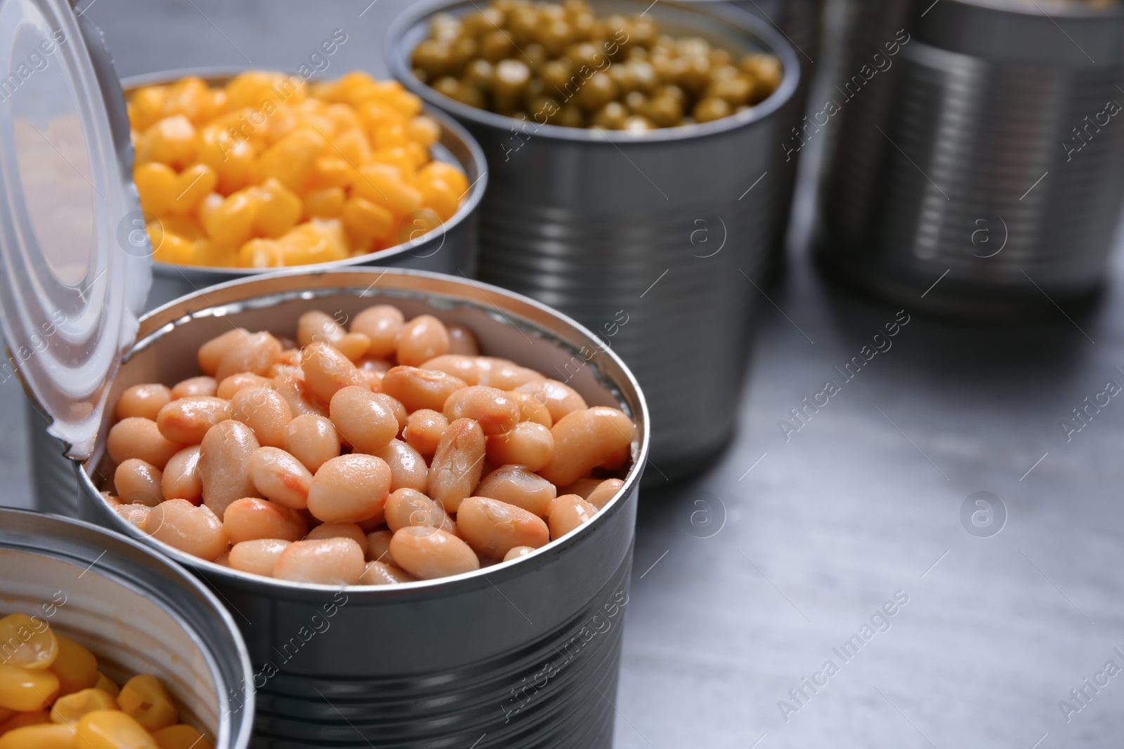 Photo of Open tin cans of conserved vegetables, closeup. Space for text