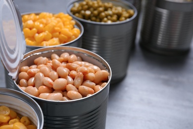 Photo of Open tin cans of conserved vegetables, closeup. Space for text