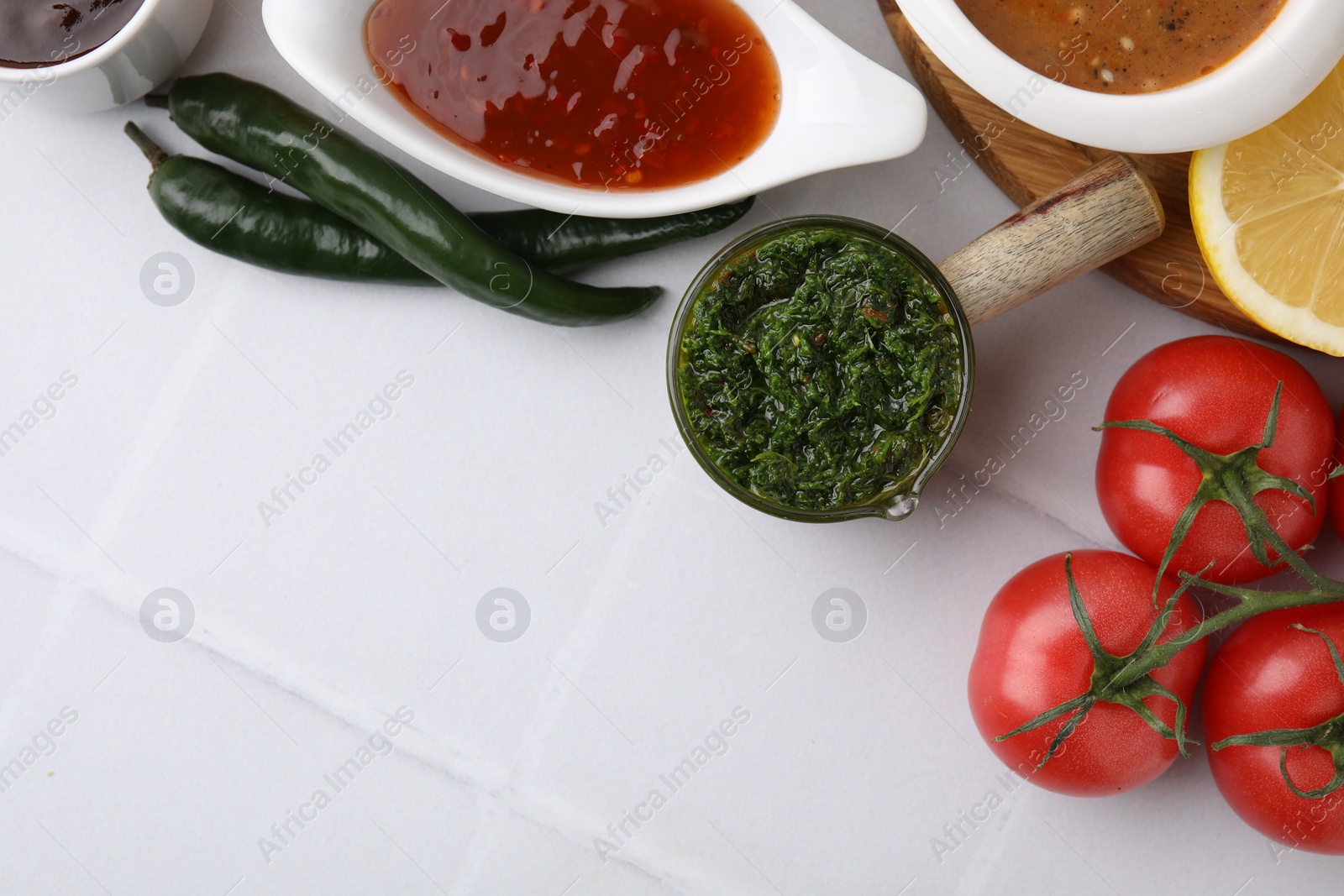 Photo of Different marinades and products on white tiled table, flat lay. Space for text