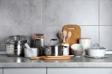 Set of different cooking utensils on grey countertop in kitchen