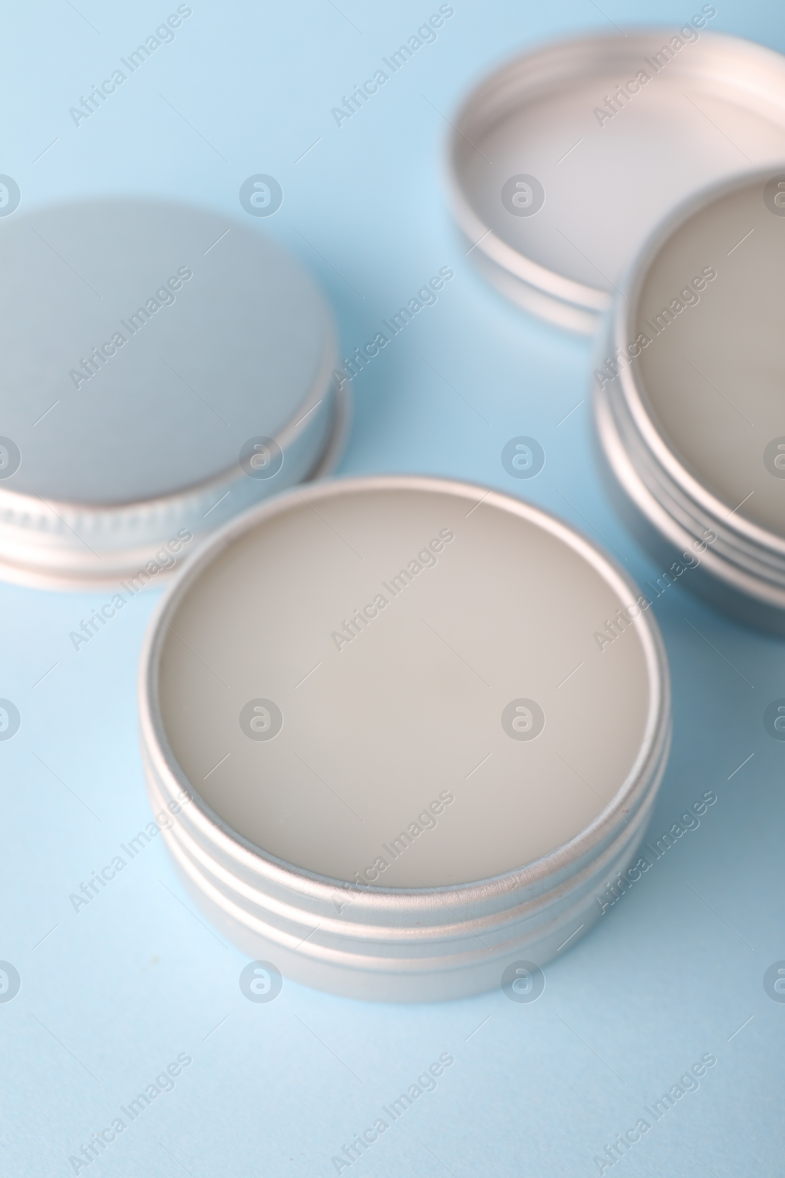 Photo of Lip balms on light blue background, closeup