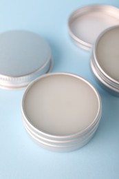 Photo of Lip balms on light blue background, closeup