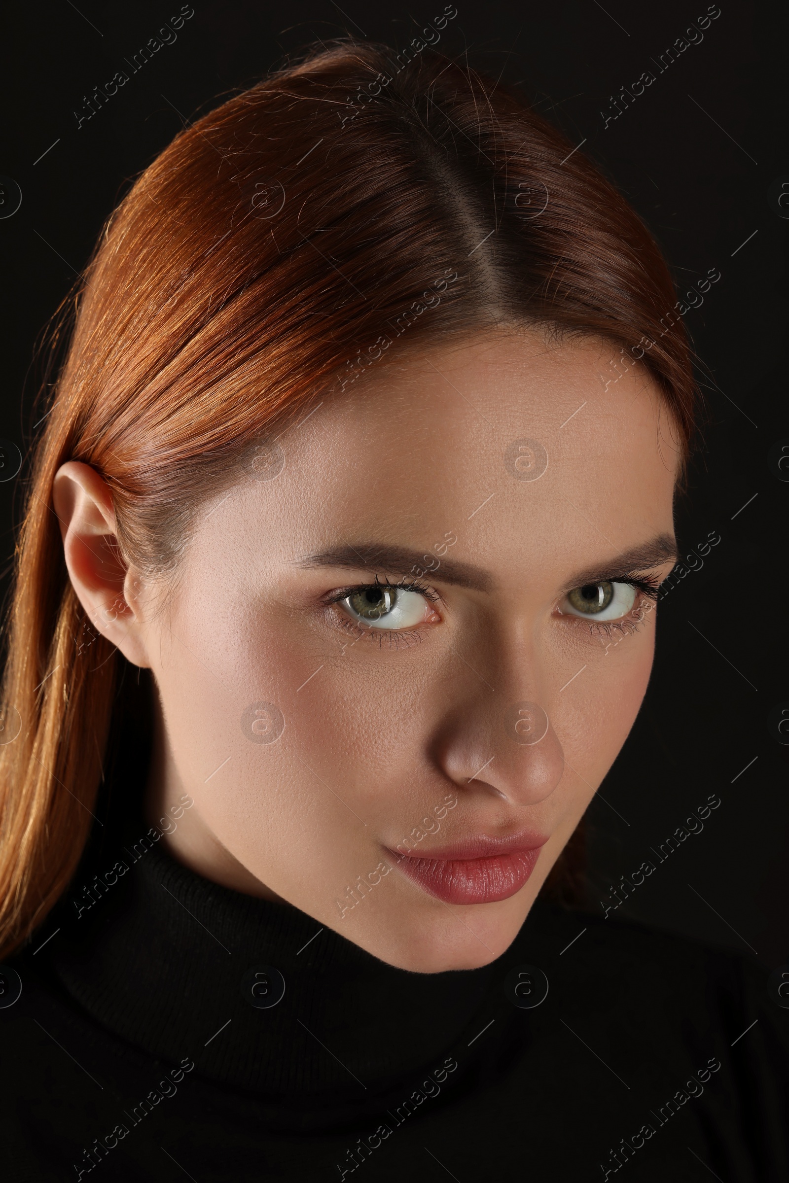 Photo of Evil eye. Young woman with scary eyes on black background