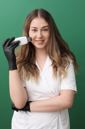 Photo of Cosmetologist with ultrasonic scrubber on green background