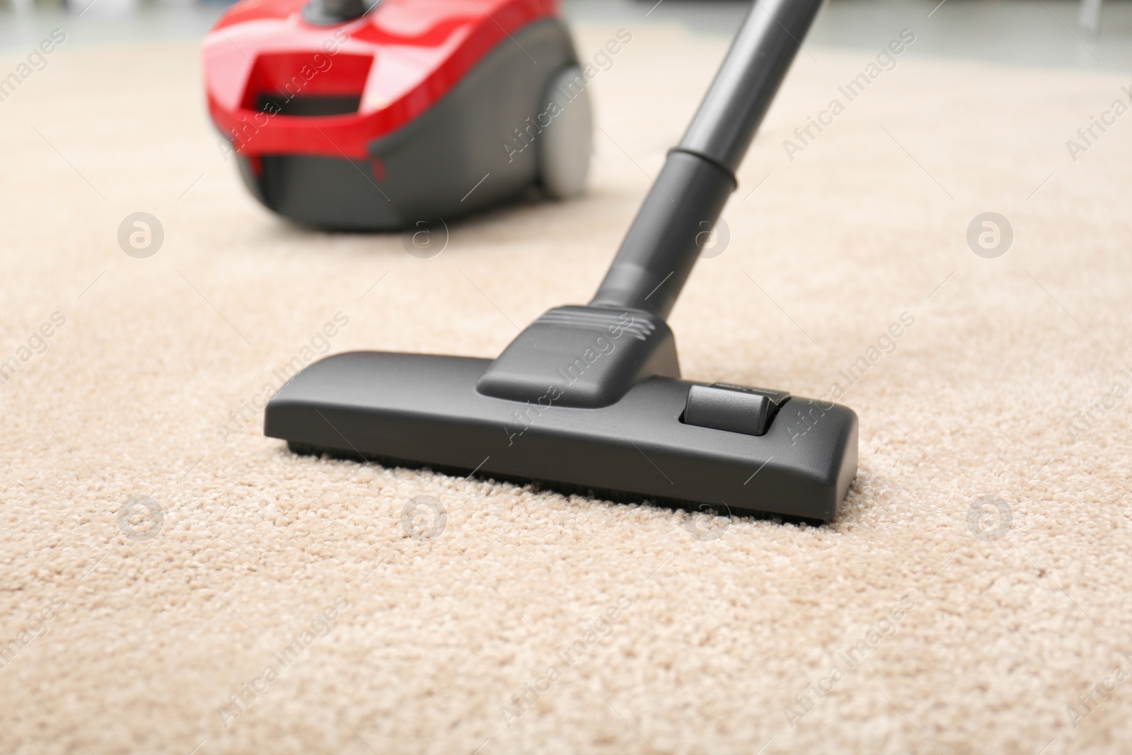 Photo of Removing dirt from carpet with modern vacuum cleaner indoors