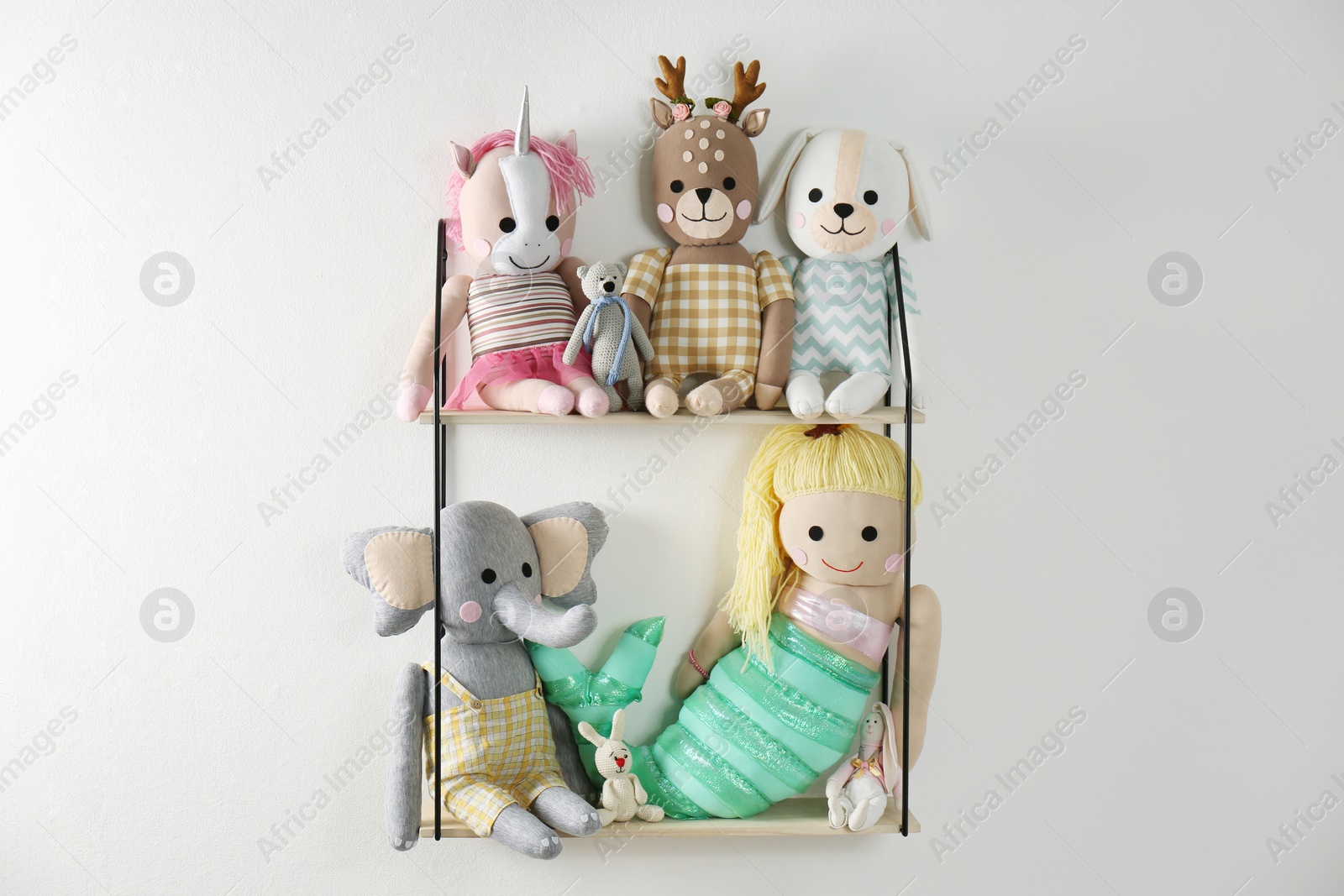 Photo of Shelf with cute toys on light wall. Baby room interior element