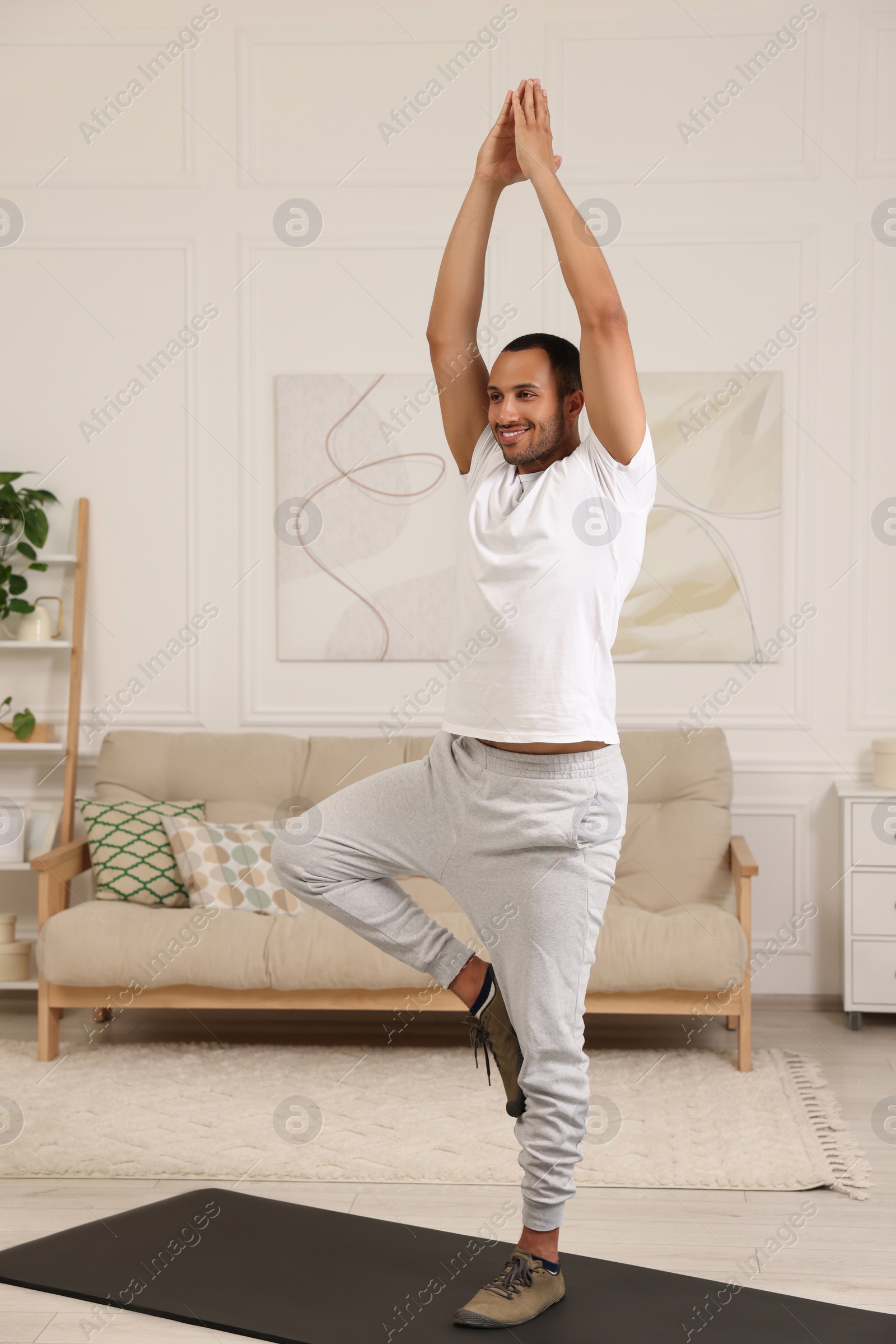 Photo of Man doing morning exercise on fitness mat at home