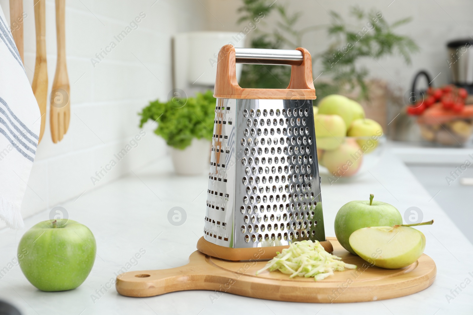 Photo of Grater and fresh ripe apples on kitchen counter