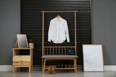 Photo of Hallway interior with modern furniture, mirror and hanging shirt