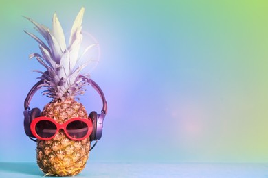 Image of Pineapple with headphones and sunglasses on color background, space for text. Summer party