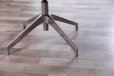 Photo of Modern office chair on wooden floor, closeup