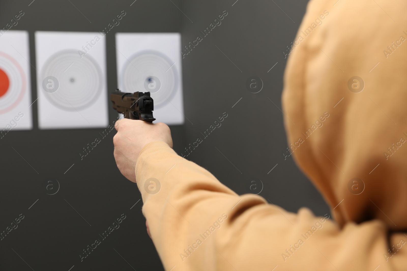 Photo of Man aiming at shooting target indoors, closeup