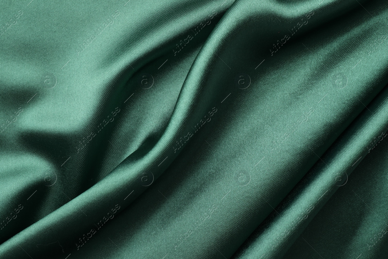 Photo of Crumpled green silk fabric as background, top view