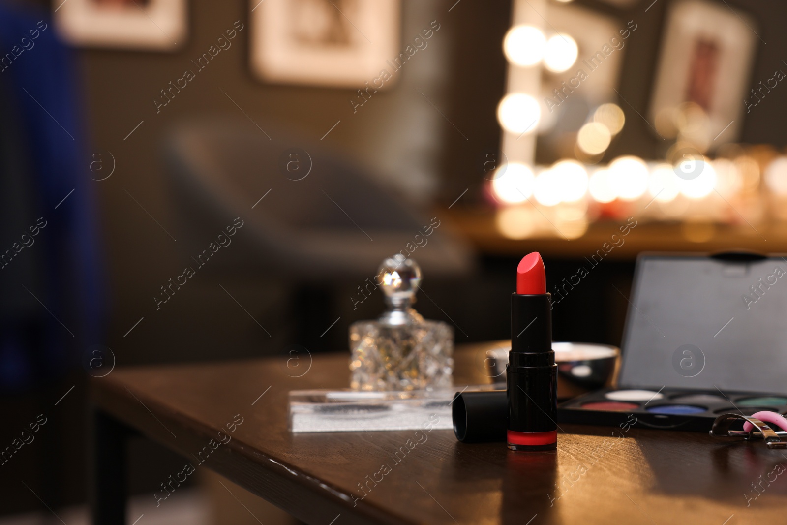 Photo of Red lipstick and other beauty products on wooden table. Makeup room