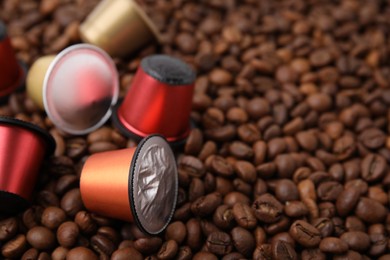 Many different coffee capsules on beans, closeup. Space for text