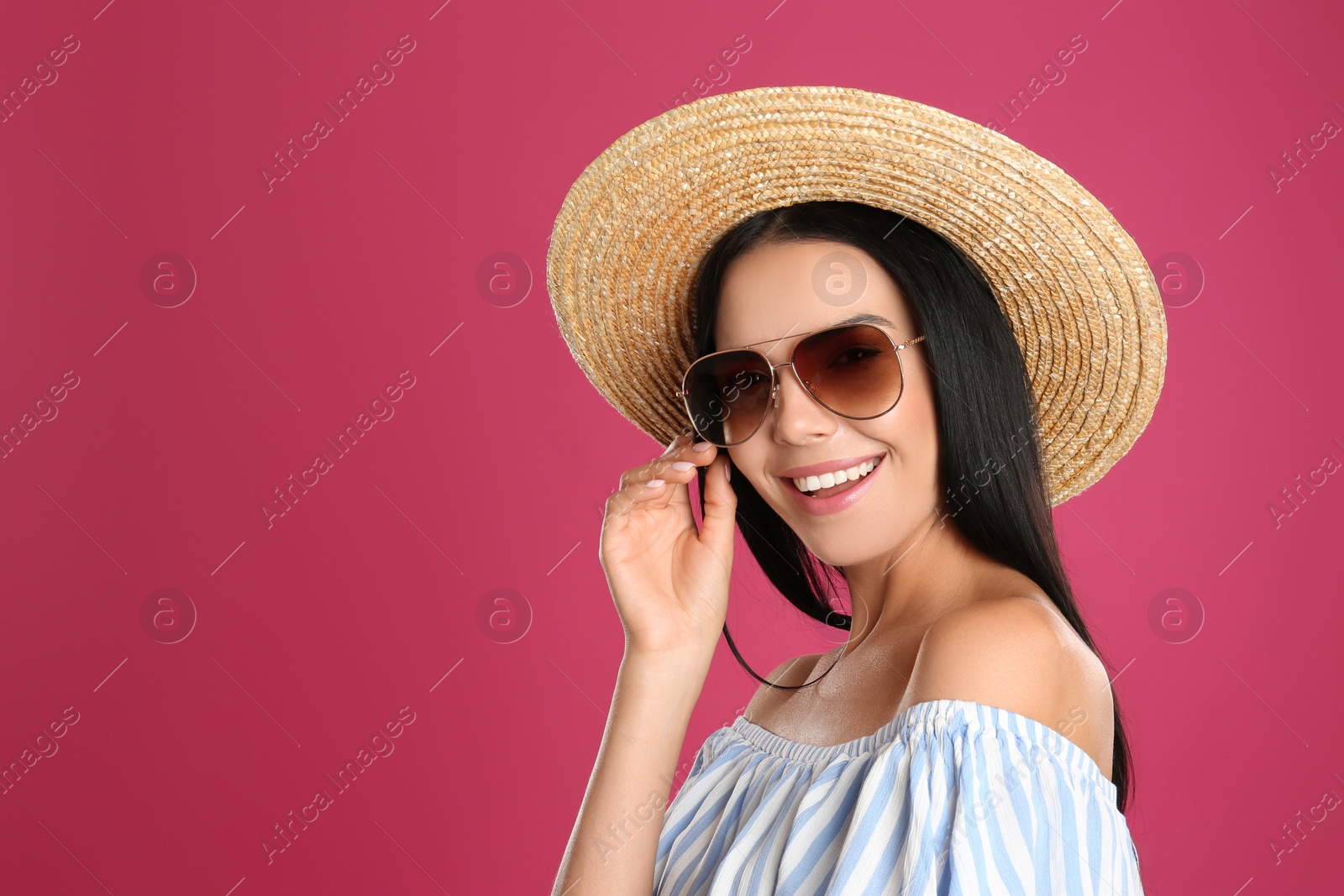 Photo of Beautiful woman wearing sunglasses on pink background. Space for text
