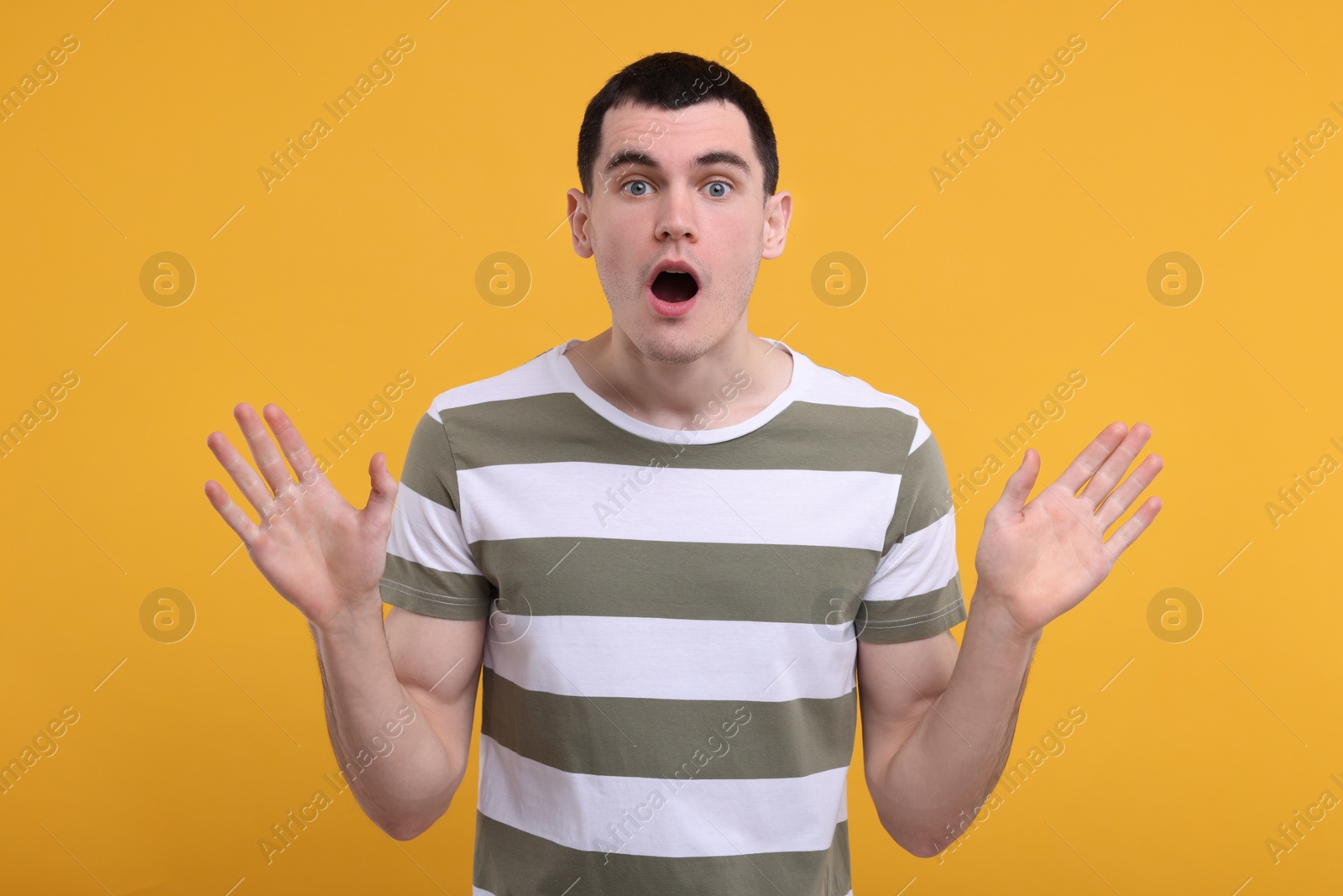 Photo of Portrait of surprised man on orange background