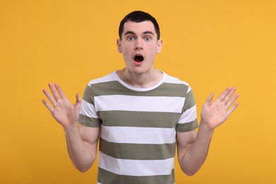 Photo of Portrait of surprised man on orange background