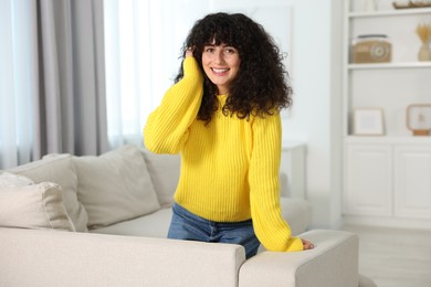Photo of Happy young woman in stylish yellow sweater indoors