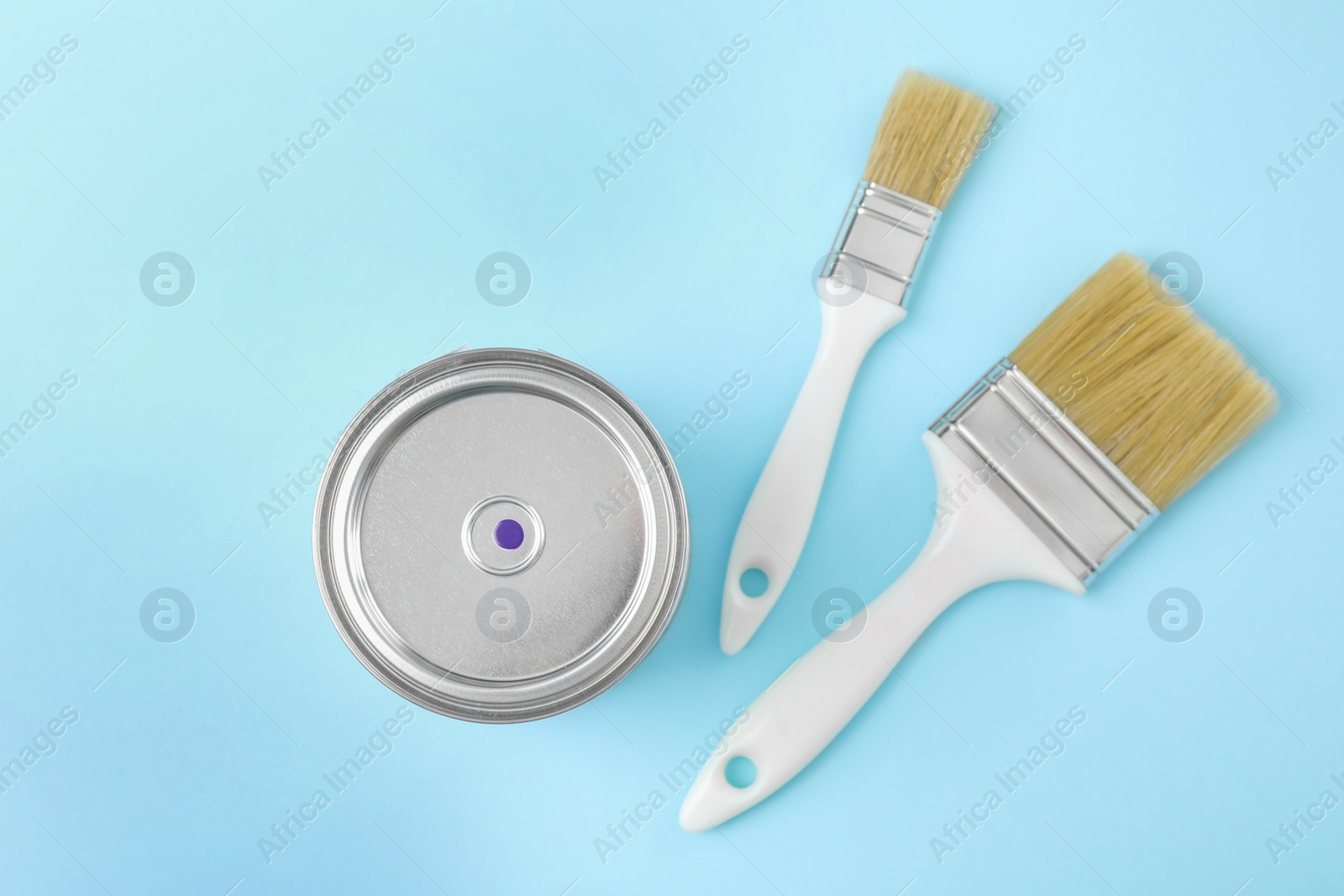 Photo of Flat lay composition with can of paint and brushes on color background