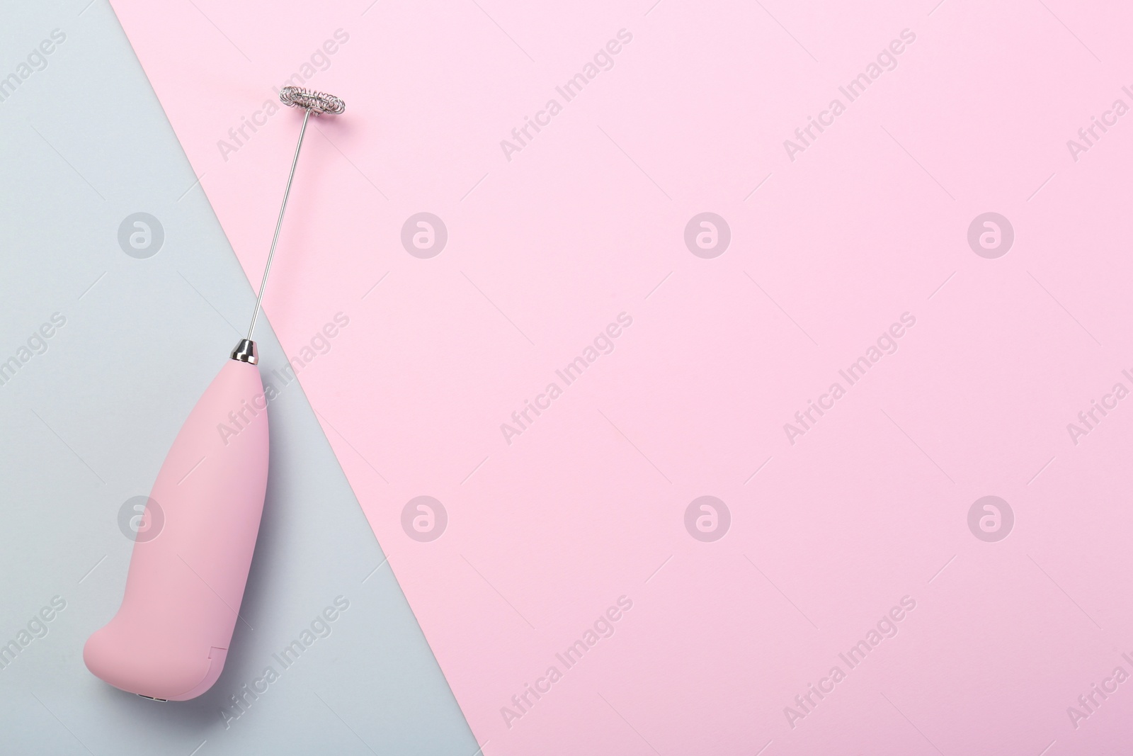 Photo of Pink milk frother wand on color background, top view. Space for text