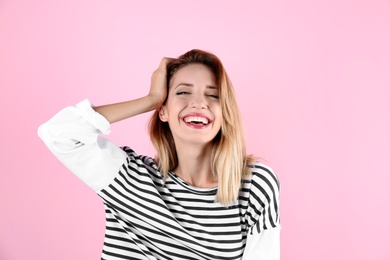 Portrait of beautiful laughing woman on color background