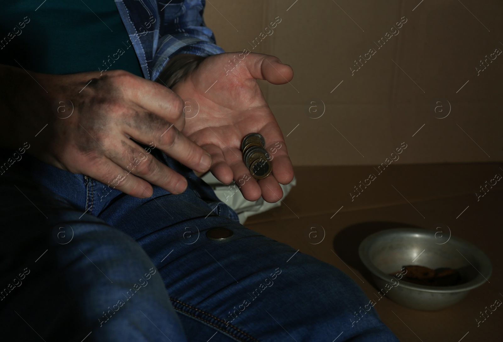 Photo of Poor senior man counting coins near cardboard, closeup. Space for text