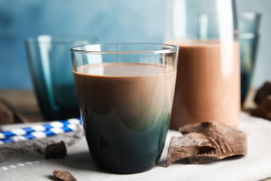 Glass of tasty chocolate milk on wooden table. Dairy drink