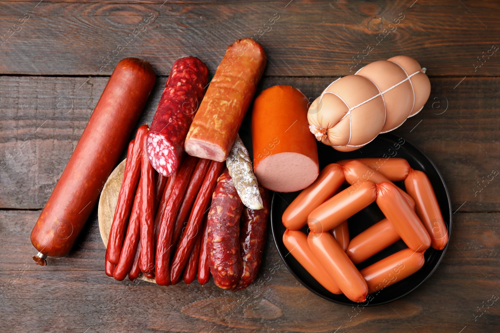 Photo of Different types of sausages on wooden table, flat lay