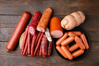 Different types of sausages on wooden table, flat lay