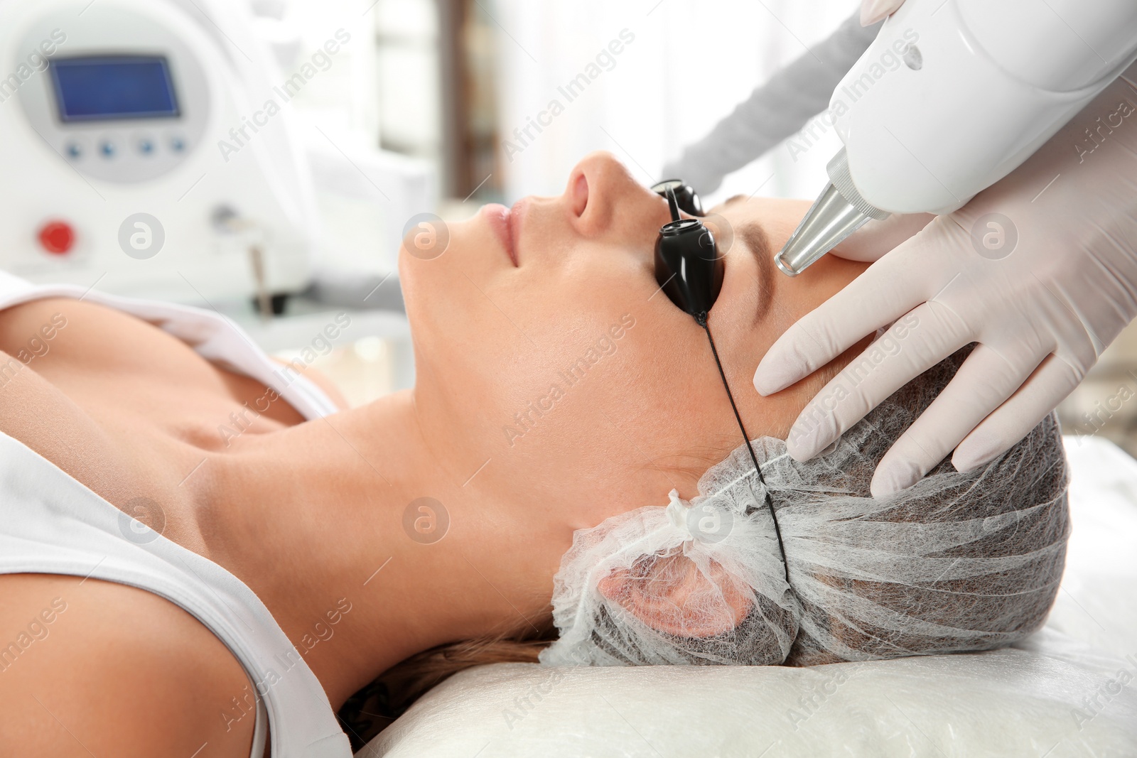 Photo of Young woman undergoing laser removal of permanent makeup in salon. Eyebrow correction