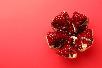 Photo of Cut fresh pomegranate on red background, top view. Space for text