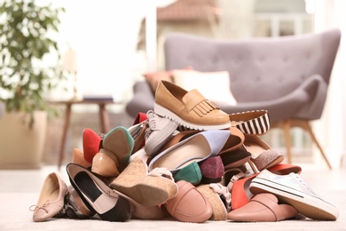 Photo of Heap of different shoes on floor in room