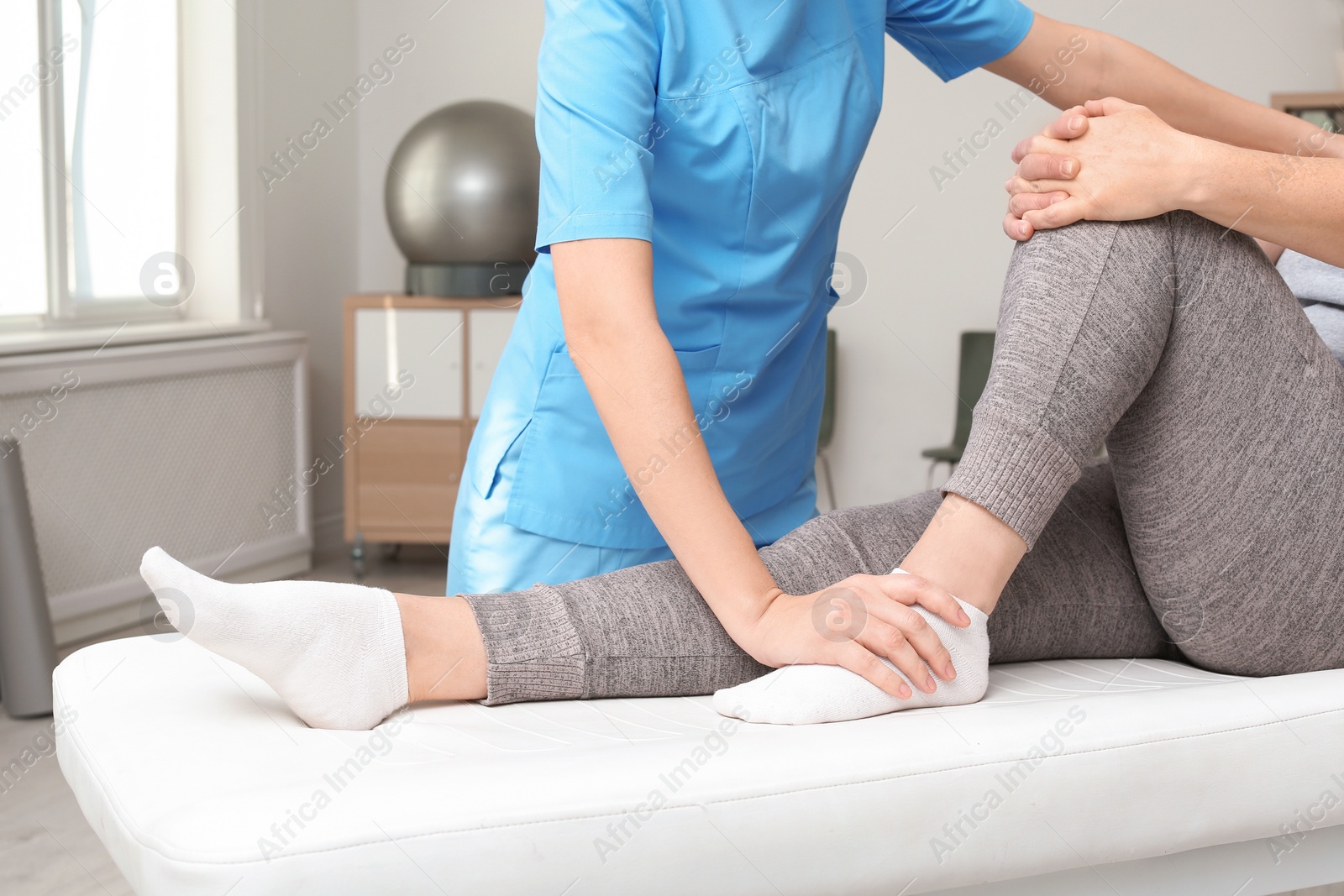 Photo of Physiotherapist working with patient in clinic, closeup. Rehabilitation therapy