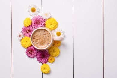 Beautiful floral composition with cup of hot coffee on white wooden background, flat lay. Space for text