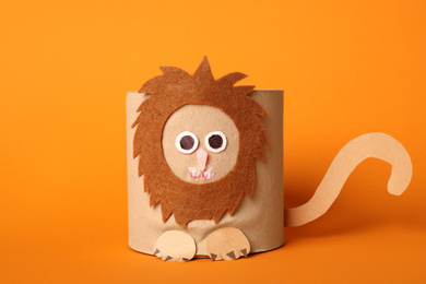 Photo of Toy lion made of toilet paper roll on orange background