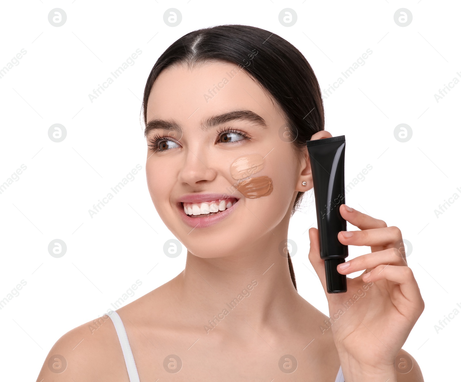 Photo of Teenage girl holding tube of foundation on white background