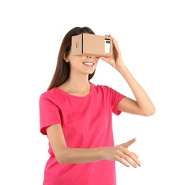 Young woman using cardboard virtual reality headset, isolated on white