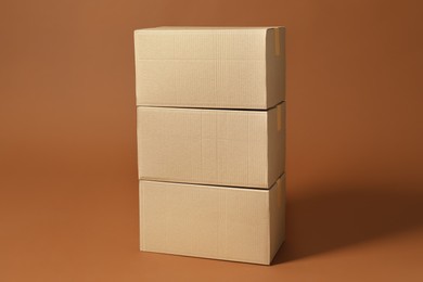 Photo of Stack of cardboard boxes on brown background