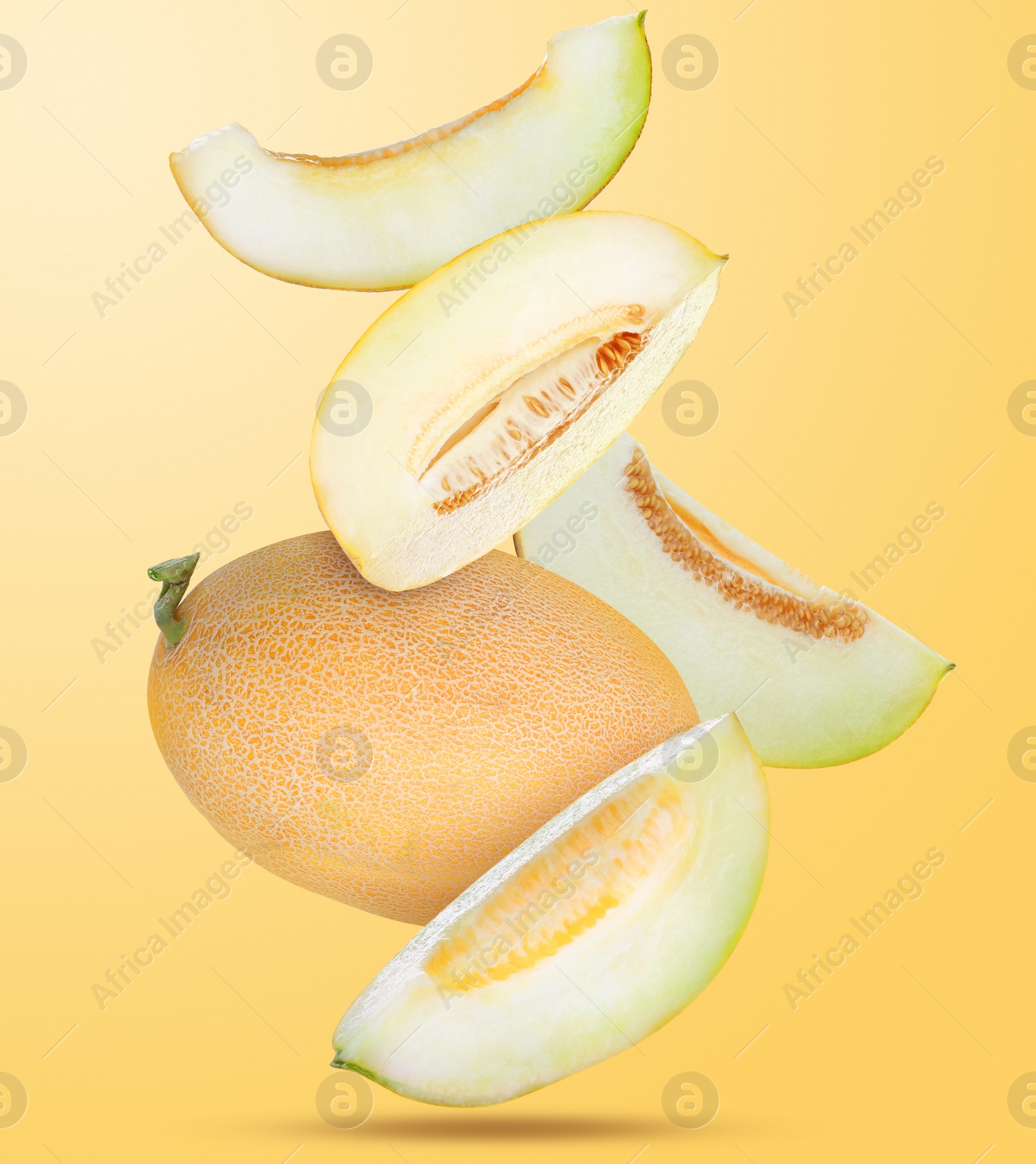 Image of Delicious ripe melons falling on pale orange background