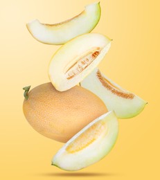 Image of Delicious ripe melons falling on pale orange background