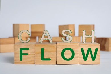 Image of Phrase Cash Flow made with letters and wooden cubes on light background